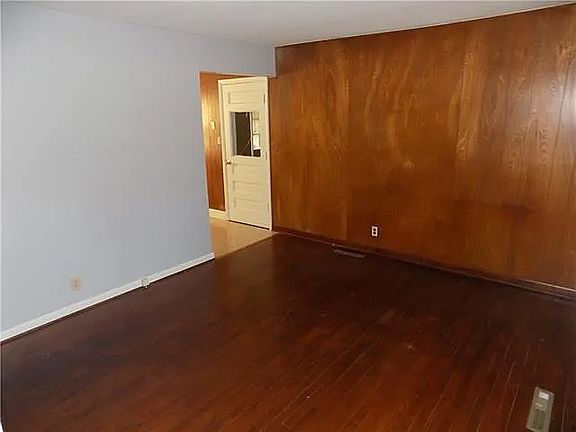 Living room has wood feature wall on one end.