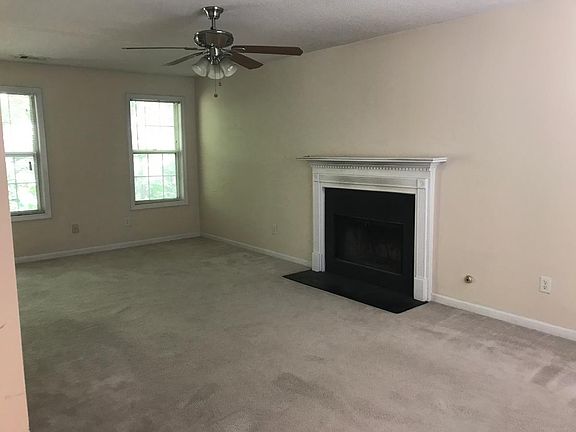 Spacious living room with fireplace and ceiling fan
