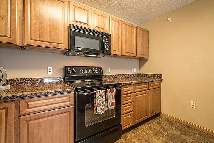 Our kitchens offer abundant cabinetry and modern black appliances, ideal for all your cooking needs.