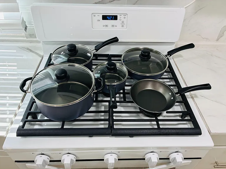 Gas range with ample cooktop space, set against sleek stone-look surfaces for everyday meal prep.