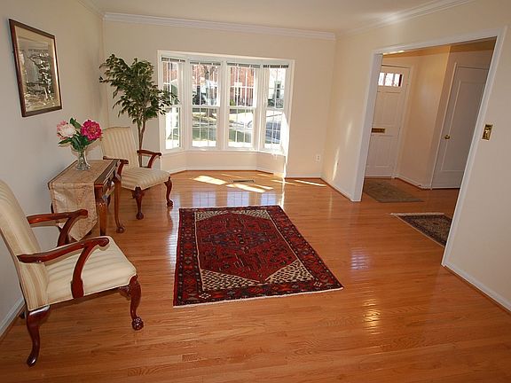 Bright Living Room with hardwood floors, bay window, and crown molding.