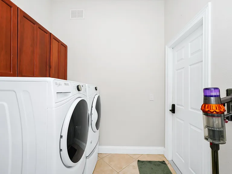Utility area with full size washer and dryer + high speed dyson vaccum cleaner.
