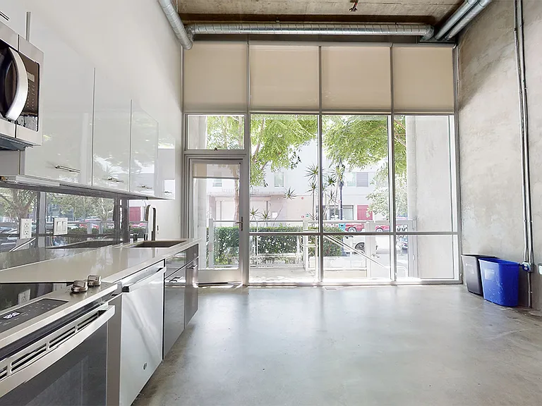 Apartment dining and living room with polished concrete or wood-style flooring.