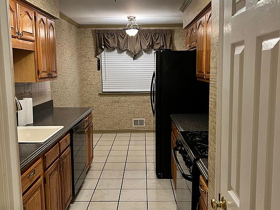 Kitchen. New countertops. Kohl sink. Appliances recent (less than a year old). Under counter lighting. Garden window behind shades. Pantry door in view to right. Only wallpapered room in house. Italian newsprint.