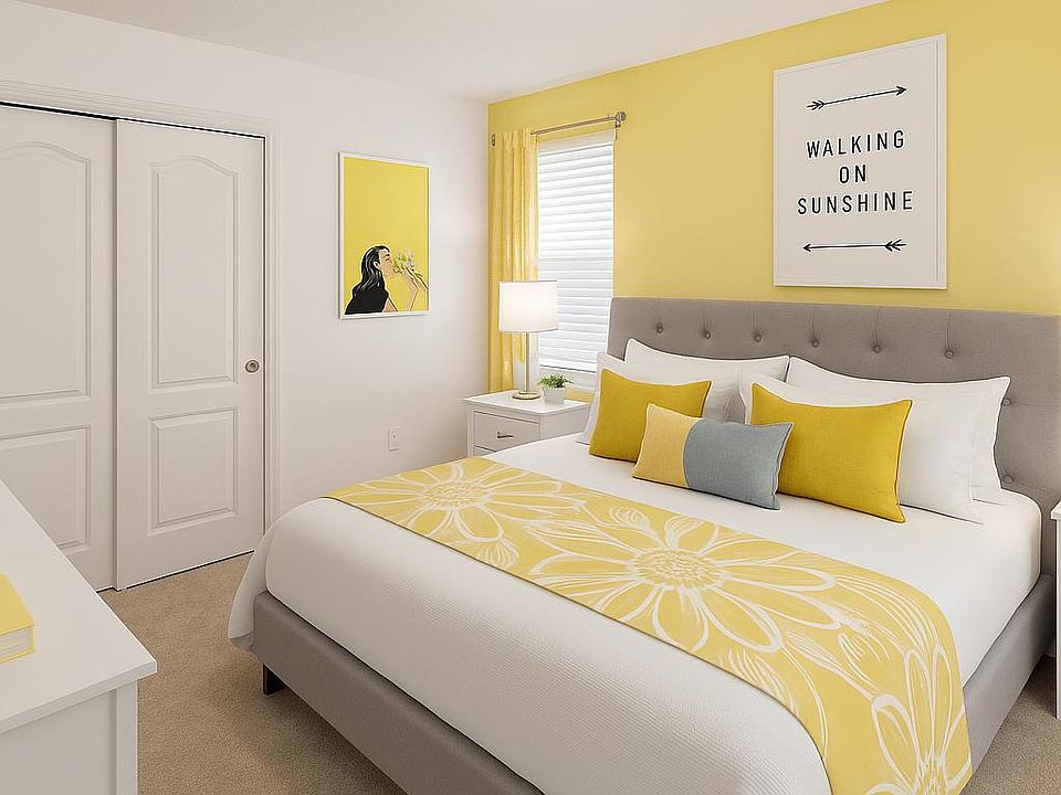 Bright and cheerful bedroom featuring a cozy bed with matching pillows, and uplifting decor for a welcoming atmosphere.