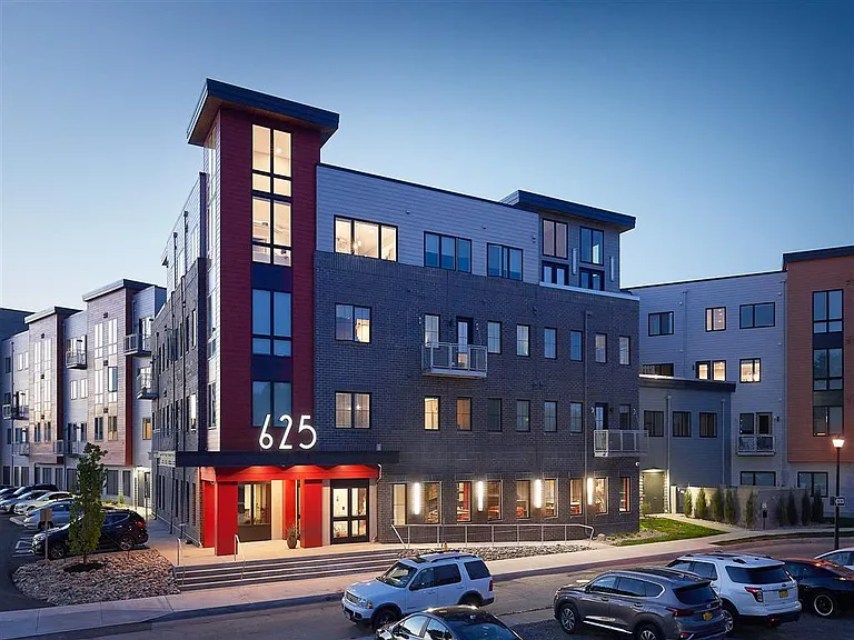 Exterior view showing front entrance to 625 S. Goodman Apartments at dusk