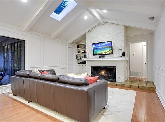 The sunken living room boasts vaulted ceilings, picture window and skylight giving it a bright, warm feel.