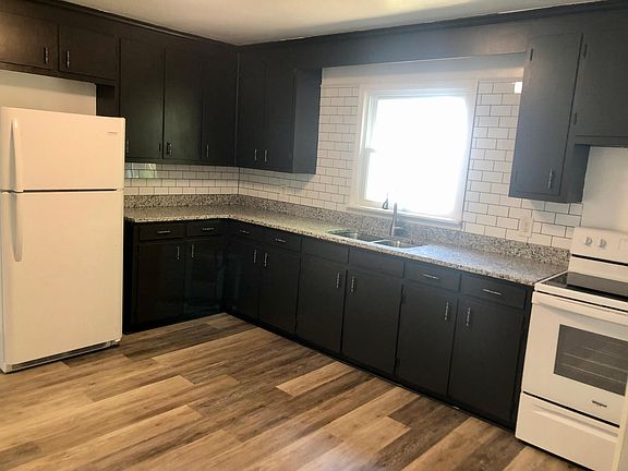 Kitchen with new appliances, sink, faucet, backsplash, granite, and luxury vinyl plank flooring.