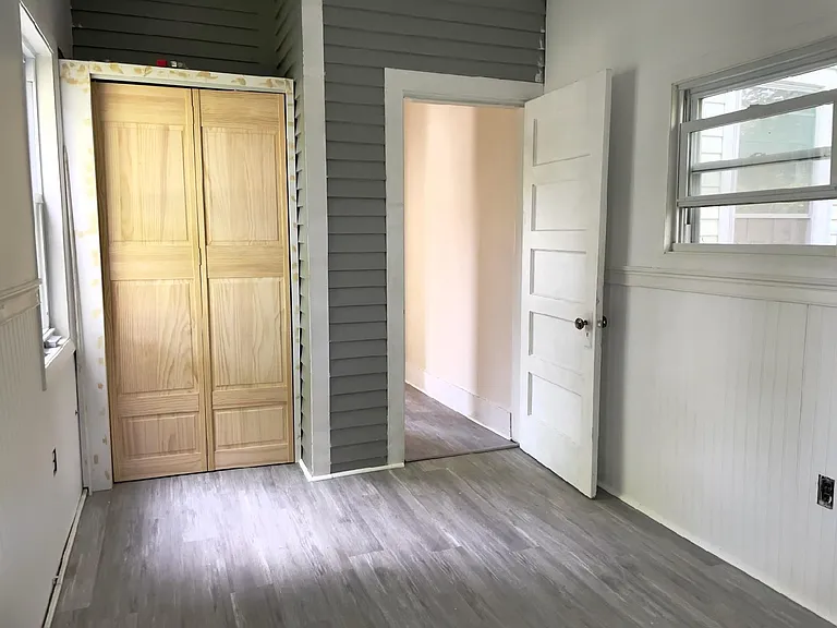 Second smaller bedroom with closet and hallway to the kitchen in background.