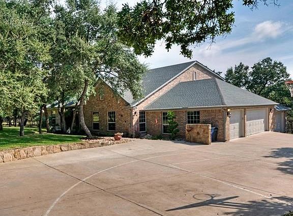 A wide concrete drive for plenty of parking or shooting three pointers on the custom basketball hoop