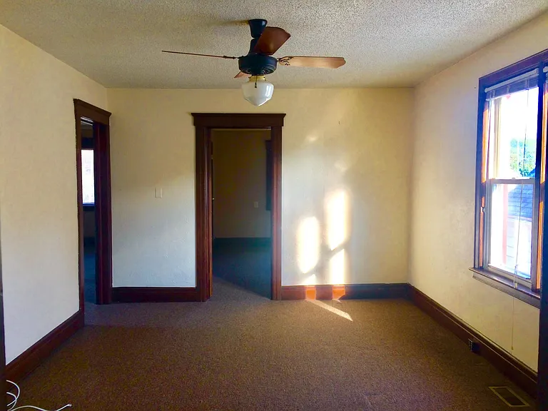 Large living room with ceiling fan. .