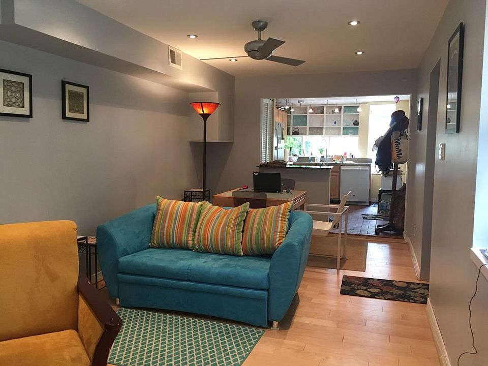 Living room w/kitchen in rear, patio though windows