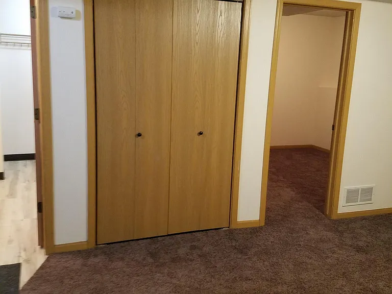 Bathroom 2 (on left), Utility closet for furnace/air, water heater and fire extinguisher, CO detector on wall outside of closet, Bedroom 4 Doorway (on right)
