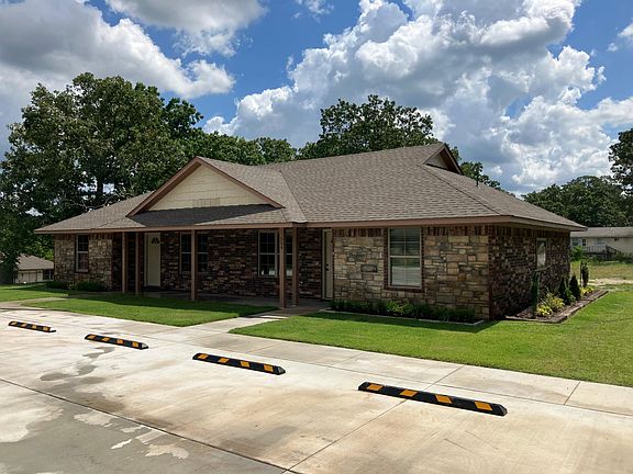 Earth tone brick and stone with evergreen landscaping, and adequate off-street lighted parking. and building soffits.