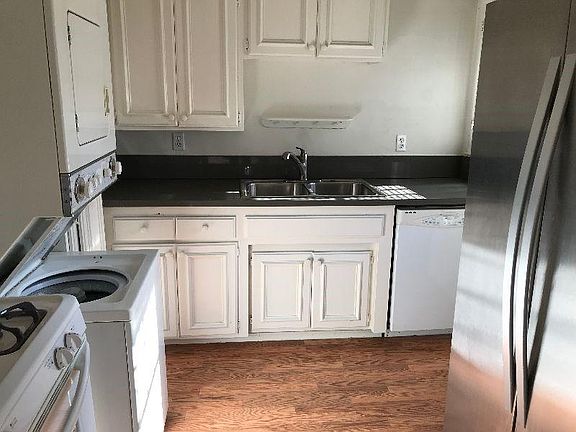 Kitchen with stacking washer dryer and stainless steel refrigerator