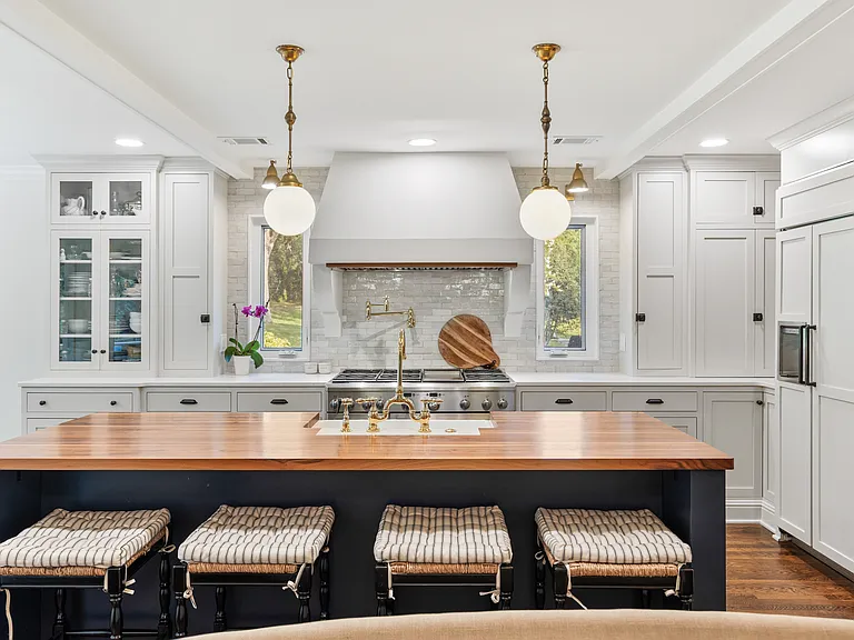 Recently updated state-of-the-art kitchen with a gas range, farm sink, all the dishware and appliances you might need, and seating for four at the kitchen counter.