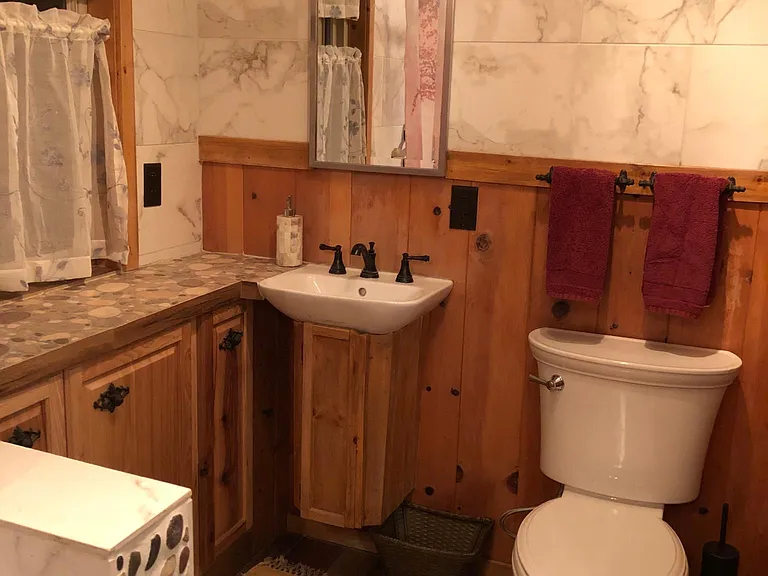 The bathroom has two sinks, one at each end of the room. the sinks are small but there is storage for each one and more .