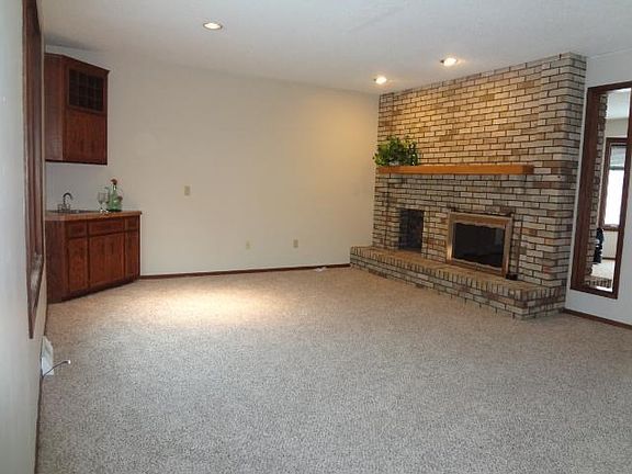 Main level family room with brick, gas fireplace that is two sided into the formal living room.  Family complete with wet bar!  This home is ready for some fun!