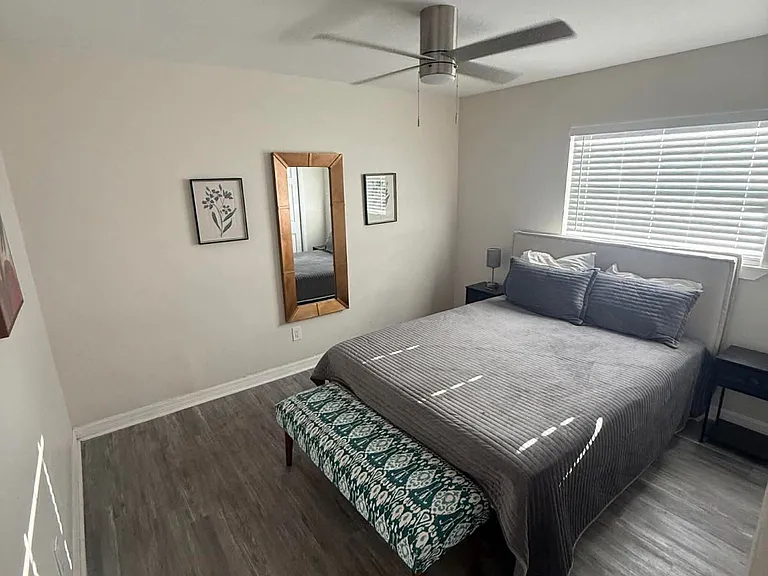Spacious private bedroom with ceiling fan, large closet, natural light, and hardwood-style floors