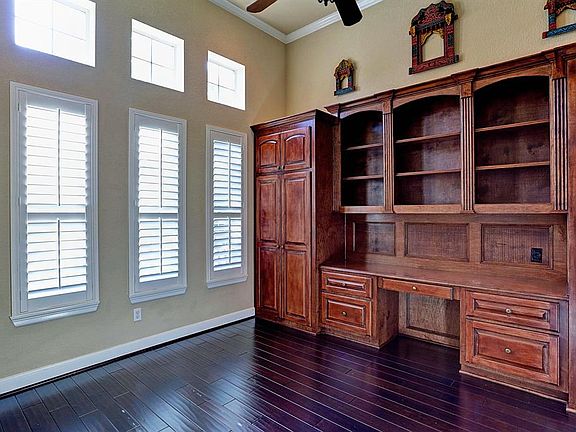 The Stufy/Library has a wall of built in cabinets with plenty of extra storage space, triple windows over the regular low e windows allow lots of natural light into the room. There is crown molding, tall ceiling, fan, and French doors in this room.