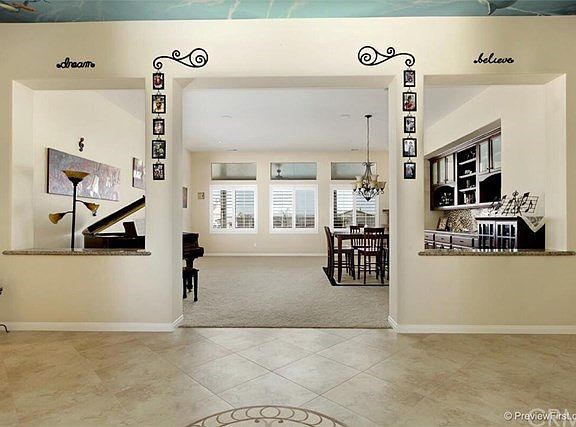 Just inside the front doors, entryway opens up into formal living and dining with large windows and custom  built in cabinetry.