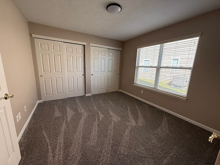 Second bedroom with lots of closet space, new carpet and new paint.