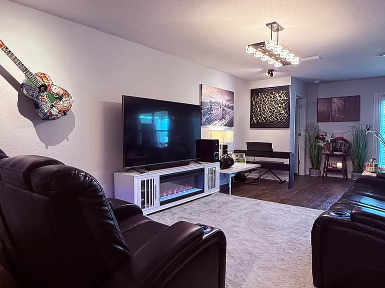 Living room with Ceiling picture and art lights and a modern chandelier.