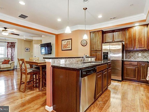 Kitchen area with island, pantry, and stainless steel appliances.