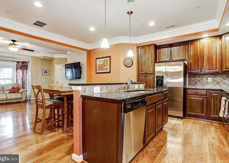 Kitchen area with island, pantry, and stainless steel appliances.
