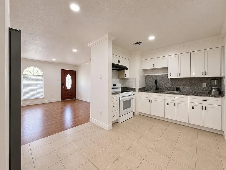 Open kitchen with ample white cabinetry, granite counters. Assigned cabinet space and refrigerator shelf space for each room