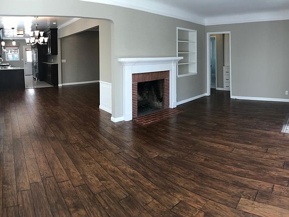 Front door opens to airy Living Room with floor-to-ceiling plantation shutters leading into dining area with chandelier, family/play room and kitchen. Front entry also leads to bedroom/bathroom hallway.