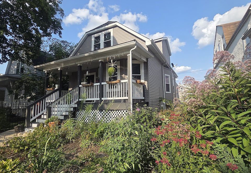 Front of the building with beautiful manicured flowers and lawn. Unit is the basement unit.