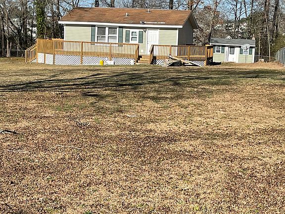 This is a picture of the side of the house and you can see the office building in the rear. And the full wraparound deck.