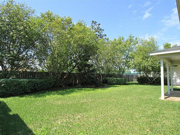 A canopy of trees lines the back fence for a tranquil and private Back Yard.