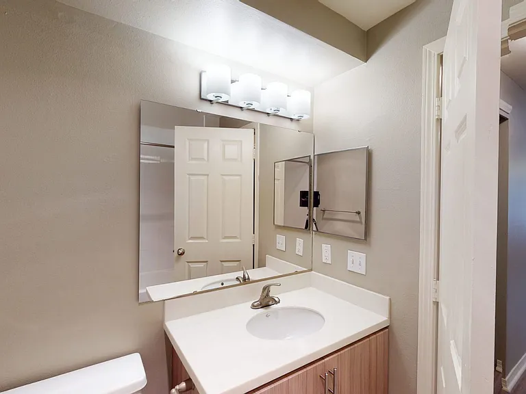 Apartment bathroom with wood-style flooring.