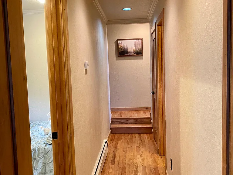 Hallway looking from the master bedroom going towards the second bedroom (door on left) and the main level guest/ 2nd bedroom bathroom.