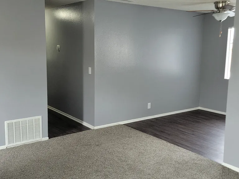 Living room view of bedroom hallway and dining room at Grand Oaks Apartments in Lake Elsinore, California.