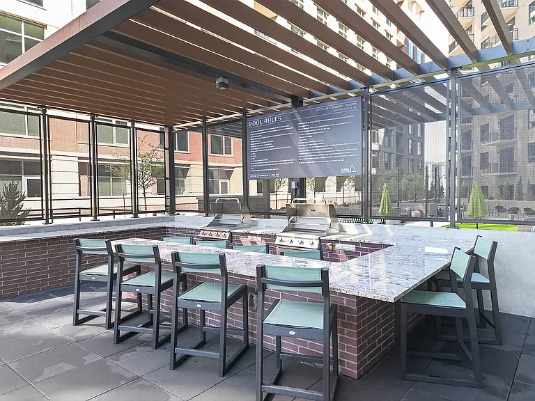 Stainless steel grills with bar seating near the pool