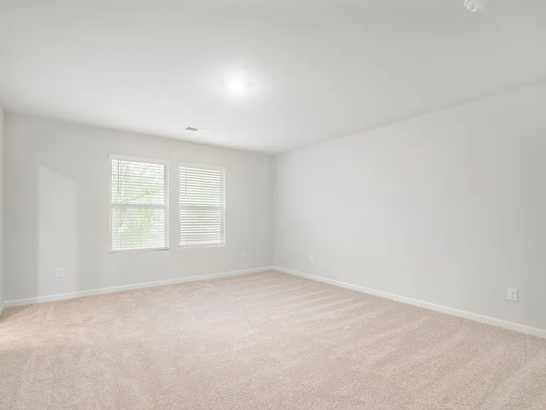 Primary bedroom upstairs with ceiling fan.