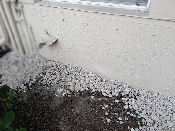 Front yard flower bed with pink marble edge.
