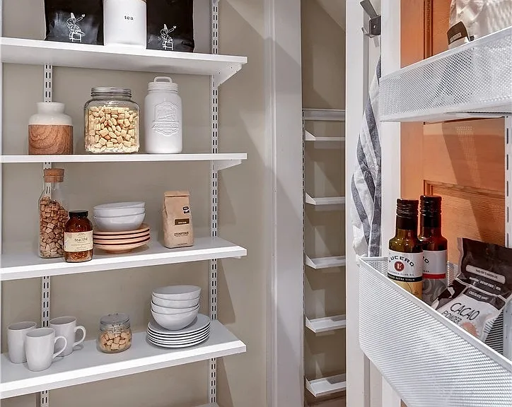This walk-in pantry off the kitchen extends deep under the stairs and is outfitted with lots of shelving.