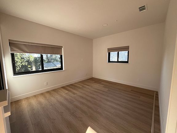Living room area with updated SPC waterproof flooring & energy efficient windows/blinds.