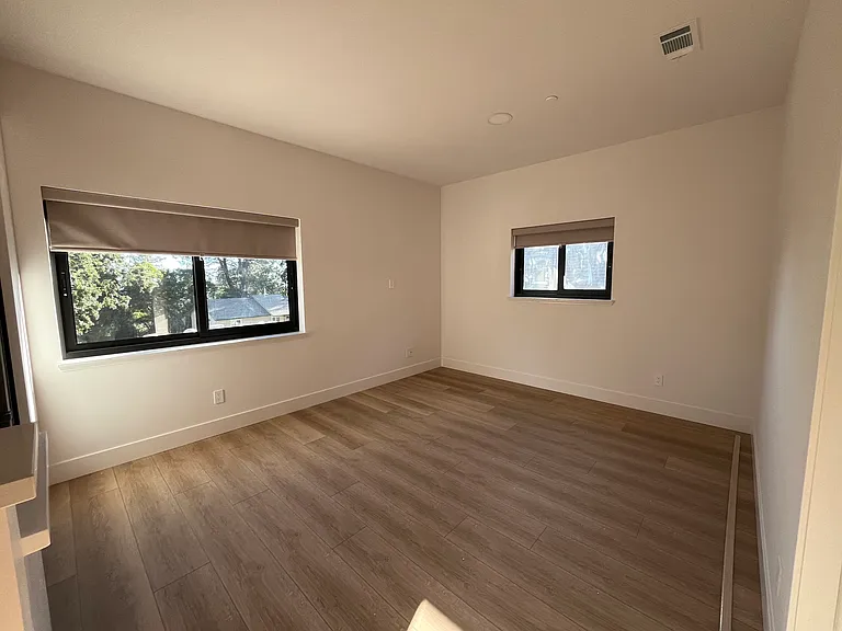 Living room area with updated SPC waterproof flooring & energy efficient windows/blinds.