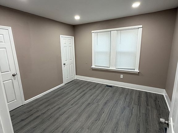 Back bedroom 1 behind kitchen area with a backyard exit door.