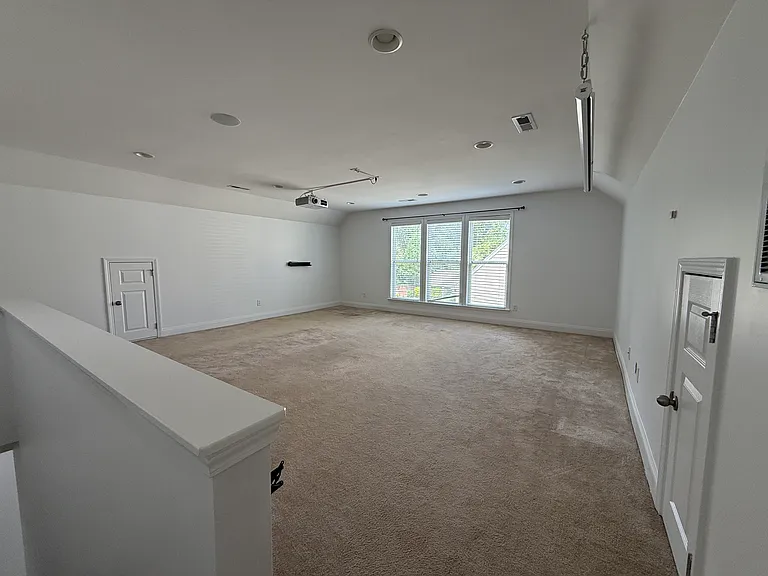 Expansive second-floor loft offering unmatched flexibility. Use it as a media room with the included built-in projector, a spacious home office, or a massive kids' play area."