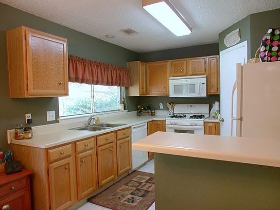 Open kitchen has lots of cabinet space, recent appliances, refrigerator stays.