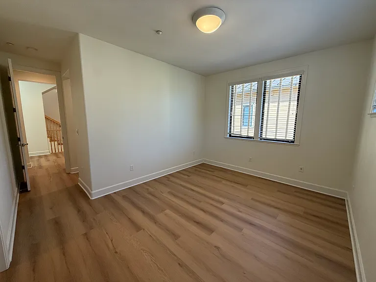 Spacious Bedroom #1 features multiple windows, vinyl flooring, walk-in closet, a separate bathroom sink and share a Jack-and-Jill style bathroom for the bathtub and toilet.