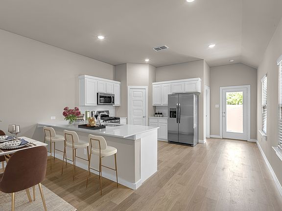 Kitchen with quartz countertops and lots of natural light! Photo virtually staged.