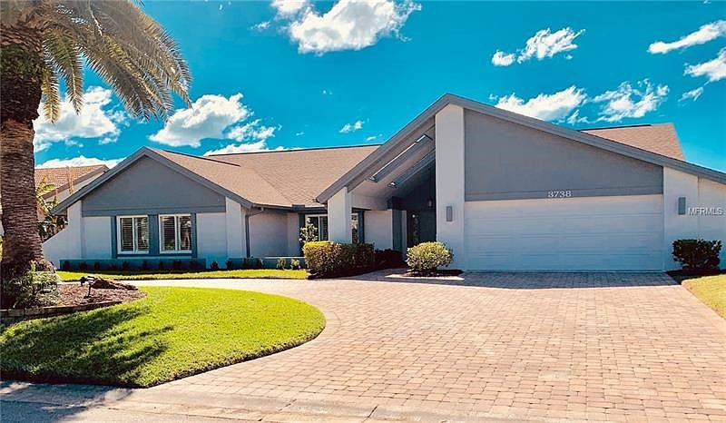 Front of Home with circular pavered driveway for ample guest parking.