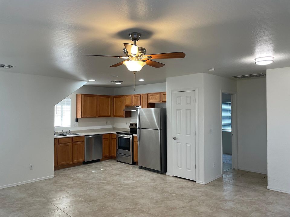 Open living room and kitchen with new tile floors and appliances.